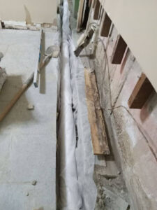 a newly laid french drain pipe in the basement of a commercial building
