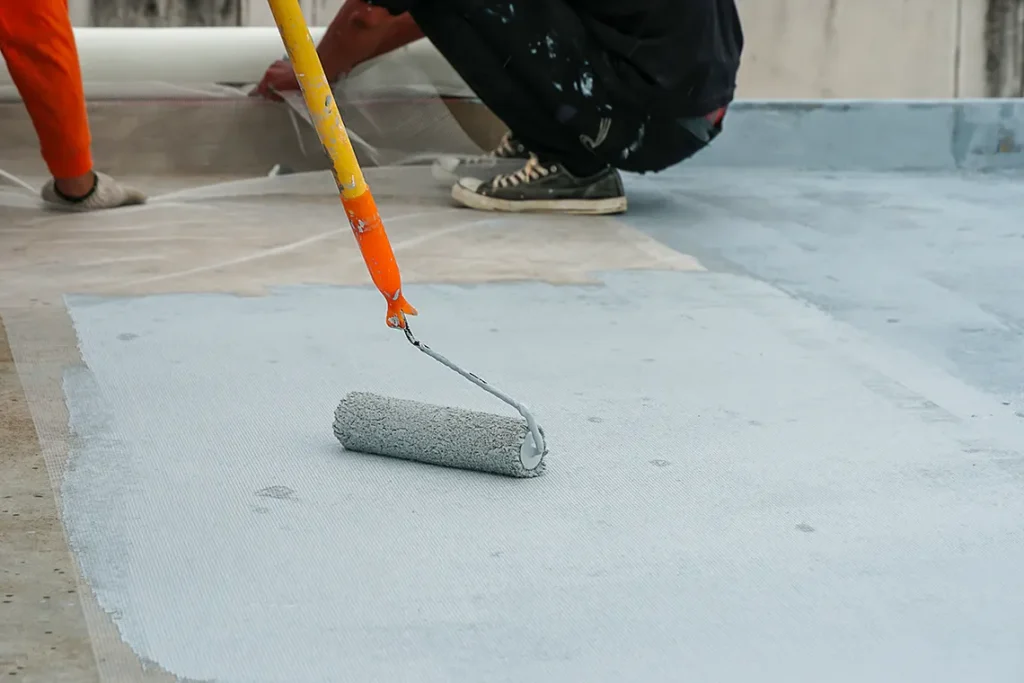 A contractor waterproofing a balcony