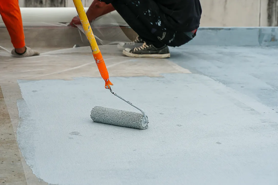 A contractor waterproofing a balcony