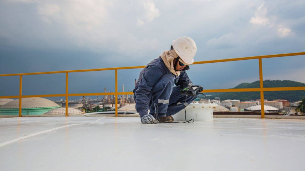 A contractor waterproofing a roof deck in Brooklyn, NY