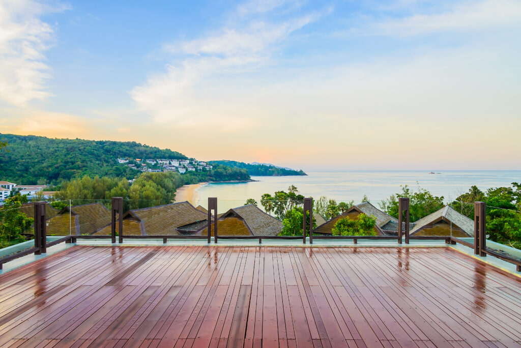 A serene and modern cedar deck overlooking a beach site.